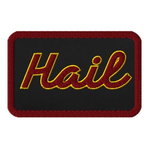 May include: Embroidered patch with the word "Hail" in a cursive font. The text is red with a yellow outline, set against a black background. The patch has a red border.