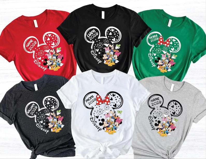 a collection of six t-shirts, each featuring a unique design with Disney characters and text. The t-shirts are arranged in a grid pattern, showcasing various colors and styles.