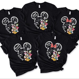 A collection of black t-shirts with Disney-themed designs, including Mickey Mouse and Minnie Mouse characters.