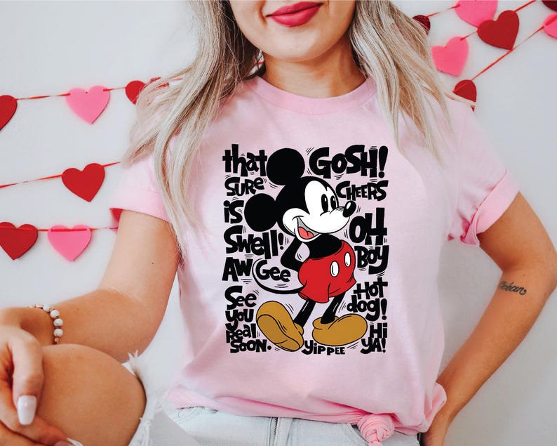 a woman wearing a pink shirt with a mickey mouse on it