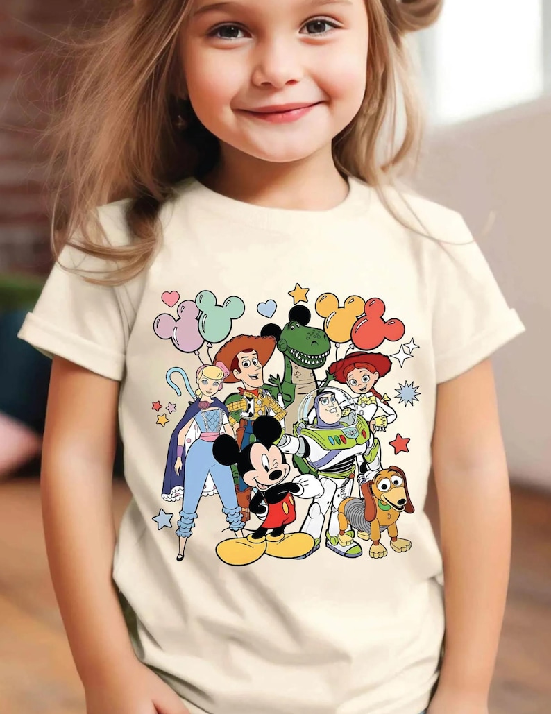 a little girl wearing a mickey mouse t - shirt