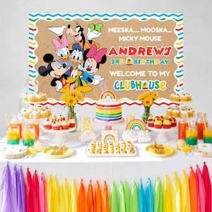 May include: A birthday party display featuring a backdrop with Disney characters, the text MEESKA MOOSKA MICKY MOUSE ANDREW'S 3RD BIRTHDAY WELCOME TO MY CLUBHOUSE, a rainbow cake, cupcakes, sunflowers in vases, and a colourful tassel table skirt.