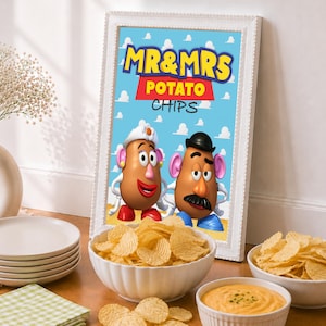 May include: A rectangular white frame containing a sign with a light blue background featuring white clouds and the text MR & MRS POTATO CHIPS. The sign displays illustrations of Mrs. Potato Head and Mr. Potato Head standing side by side.