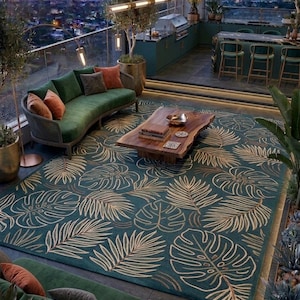 May include: An outdoor living space with a green sofa, a wooden coffee table, and a teal rug with a gold leaf pattern. The space includes a bar, grill, and city view, creating a luxurious and relaxing atmosphere.