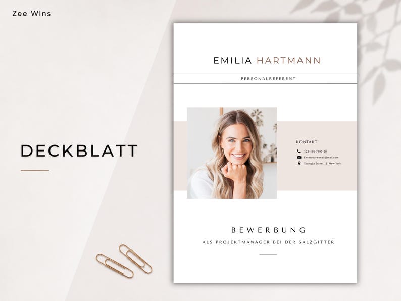 May include: A resume template with the name "Emilia Hartmann" at the top. The document includes a photo of a smiling woman, contact information, and the word "Deckblatt" and "Bewerbung" in the design. Two gold paper clips are at the bottom.