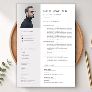 Puede incluir: Una plantilla de currículum vitae profesional en blanco y negro con una foto de un hombre con gafas. El currículum incluye secciones para información personal, cualificaciones y experiencia. Un bolígrafo dorado y una pequeña ramita verde están sobre una bandeja de madera.