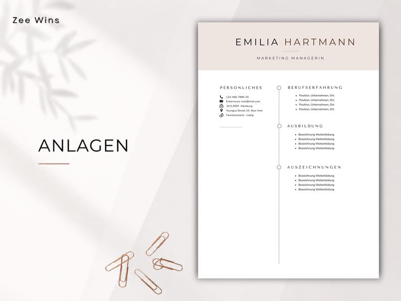 May include: A resume template with a light beige and white color scheme. The name "Emilia Hartmann" and the title "Marketing Managerin" are at the top. The word "ANLAGEN" is in the lower left corner. Several gold paper clips are scattered.
