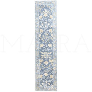 a long, narrow rug with a floral pattern in shades of blue and white.