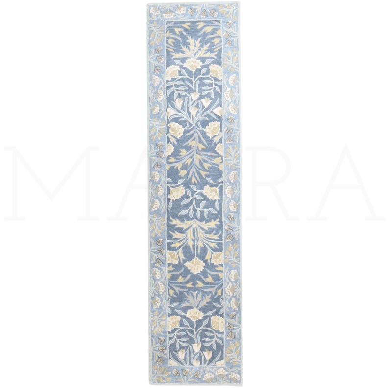 a long, narrow rug with a floral pattern in shades of blue and white.