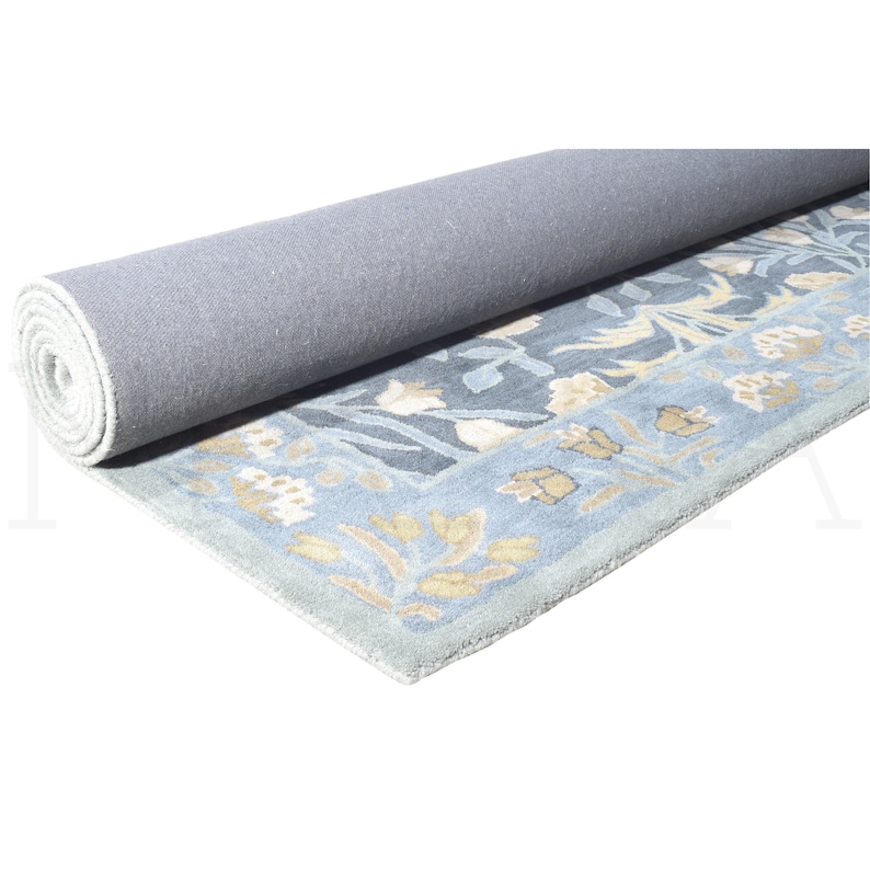 A gray carpet with a floral pattern is rolled up and placed on a white surface.