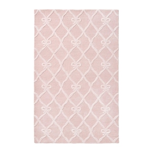 May include: A rectangular area rug in a soft pastel pink hue featuring a raised white lattice pattern. The design consists of intersecting lines that form a diamond grid, with small decorative bows positioned at each intersection point.
