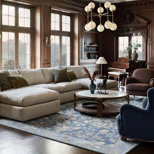 a spacious and elegantly furnished living room with large windows, wooden paneling, and a chandelier. The room is furnished with a large sectional sofa, a coffee table, and a piano, creating a cozy and inviting atmosphere.