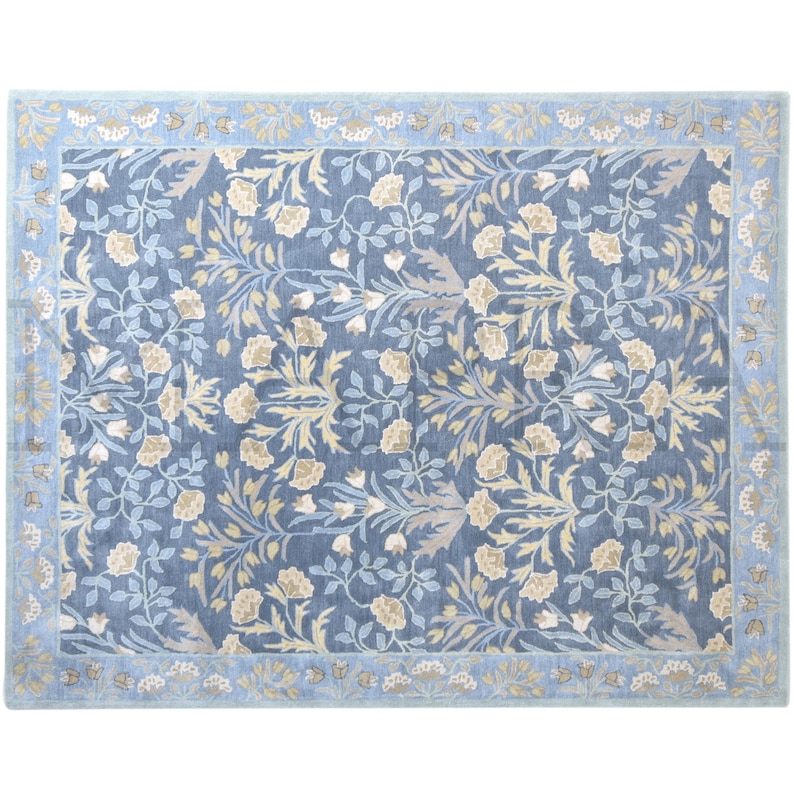 a large, square rug with a floral pattern in shades of blue and yellow. The rug has a decorative border around the edges, adding to its overall aesthetic appeal.