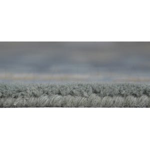 a close-up view of a textured gray carpet or rug, with a blurred background that appears to be a cloudy sky.