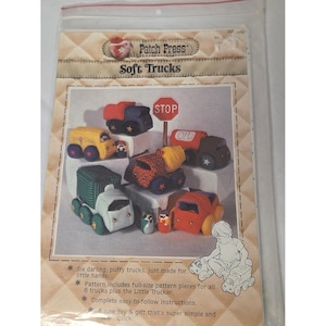 Pode incluir: Um pacote de moldes de costura intitulado Patch Press Soft Trucks com seis caminhões de tecido coloridos e uma pequena figura. A capa mostra um caminhão de sorvete amarelo, um caminhão basculante azul, um caminhão-tanque e outros veículos.
