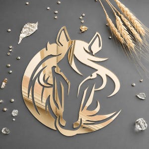May include: A gold-colored, reflective wall decoration shaped like a stylized horse head. The design features flowing, abstract lines that form the mane and facial features of the horse, creating a smooth, mirror-like surface finish.