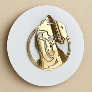 May include: A circular wall art piece featuring a white round base with a gold-colored reflective cutout of a dog head profile enclosed within a thin gold circular frame. The design displays the silhouette of a canine with detailed facial features.