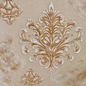 May include: A textured wall surface featuring a large, raised damask pattern in shades of beige, cream, and white. The design consists of symmetrical, ornate floral motifs with swirling leaves and petals, creating a three-dimensional effect.