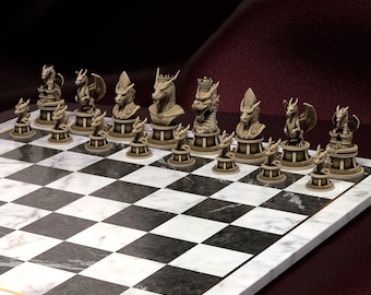 May include: A dragon-themed chess set with beige and gold pieces on a marble chessboard. The chess pieces are detailed dragon figures. The chessboard has black and white squares and gold edging. The set is displayed on a burgundy surface.