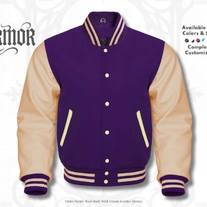 Puede incluir: Una chaqueta universitaria con cuerpo de lana color violeta y mangas de cuero crema. Presenta cierre de botones a presión, dos bolsillos laterales con ribete crema y puños y cuello de canalé a rayas. El texto dice NURMOR.