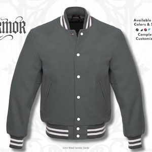 May include: A charcoal grey varsity jacket with a snap-button front closure. The jacket features a ribbed collar and cuffs with white stripes. The text NURMOR is visible on the top left, and the text Available in All Colours & Sizes is on the right.
