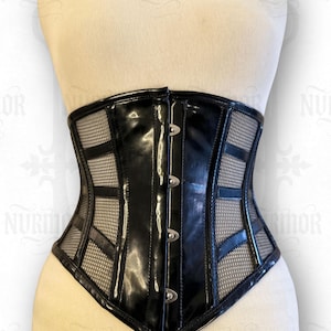 May include: A black corset with a glossy finish and mesh panels. The corset features a structured design with vertical and horizontal accents, secured with silver-toned clasps. The garment is displayed on a mannequin.