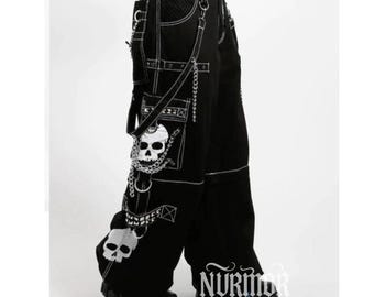 Könnte beinhalten: Schwarze Hose mit weitem Bein, weißen Kontrastnähten, mehreren Cargotaschen und silberfarbenen Metallketten. Die Hose ist mit weißen Totenkopf-Grafiken an den Seitentaschen und am unteren Bein verziert und enthält Riemen mit Metallbeschlägen.