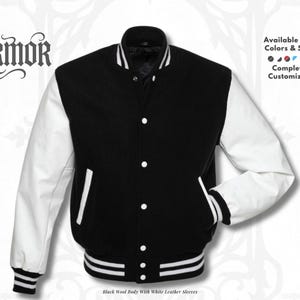 Puede incluir: Chaqueta universitaria negra de lana con mangas de cuero blanco. Cuenta con cierre de botones, puños acanalados blancos y dobladillo a rayas. La chaqueta tiene un diseño clásico con el texto "NURMOR" en la parte superior.
