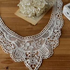 Può includere: Bordura di pizzo bianco per collo con bordo smerlato e motivo floreale. La bordura è larga circa 25 cm e lunga 35 cm.