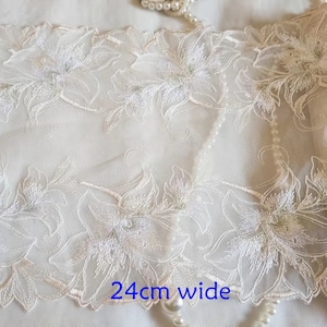 May include: White floral lace trim with a delicate design. The trim is 24 inches wide.