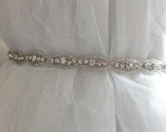 May include: A silver beaded belt with clear rhinestones, perfect for adding a touch of sparkle to a wedding dress or other formal attire.
