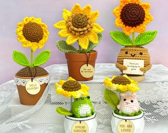 May include: A collection of handmade crochet sunflower decorations in small pots. The sunflowers are yellow and brown, with green leaves. Some pots have tags that read "Smile Everyday", "You are my sunshine", "Thank you for helping me grow", "Spread Sunshine", and "You are loved".