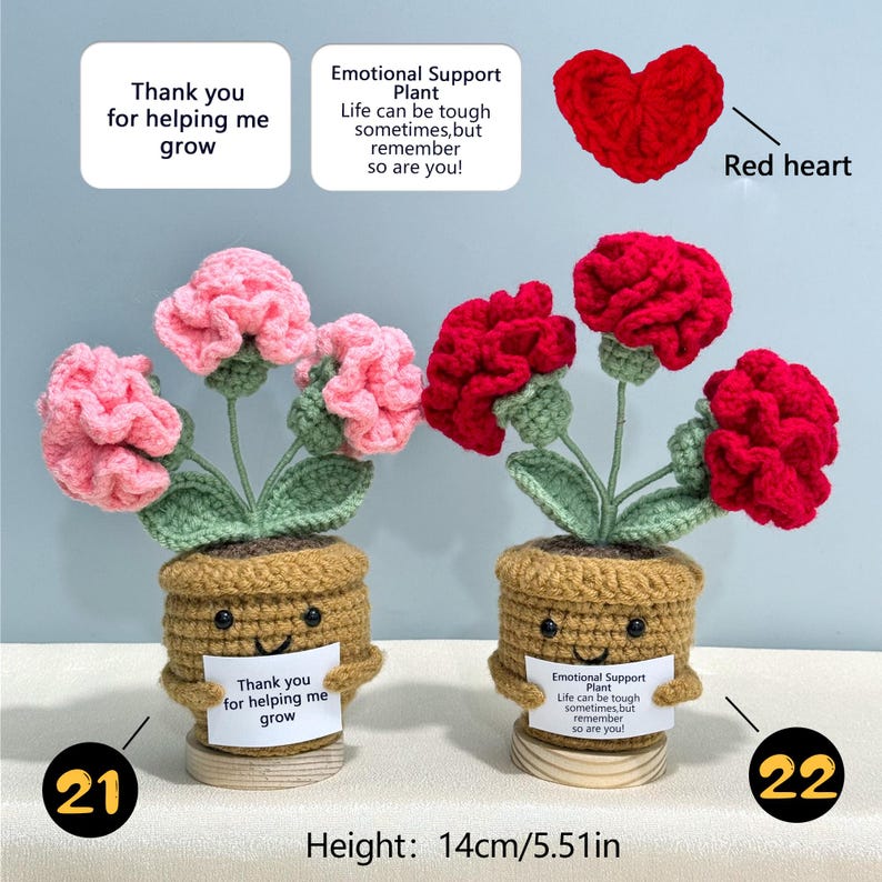 Pu&ograve; includere: Composizioni floreali all'uncinetto in vasi marroni con facce sorridenti. Uno ha fiori rosa, l'altro rossi. Ogni vaso contiene un cartello con testo. Viene mostrato anche un cuore rosso. Altezza: 14 cm.