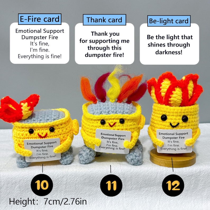 May include: Three handmade crochet figures in the shape of yellow buckets with smiling faces and gray legs. Each holds a sign that reads "Emotional Support Dumpster Fire." The figures have red and yellow flame-like accents. Height: 2.76 inches.