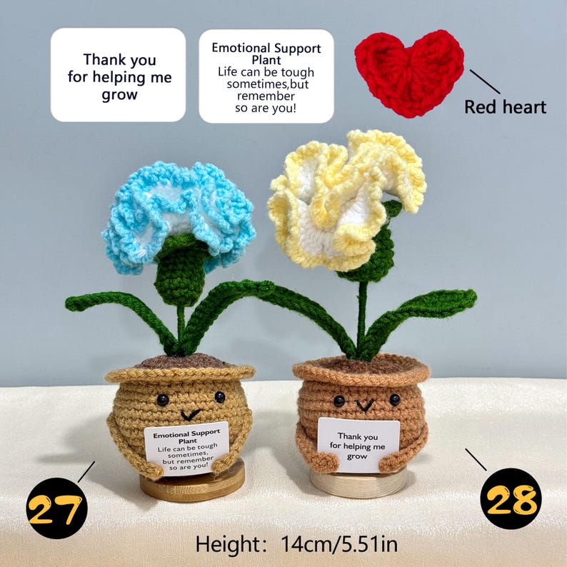 Pu&ograve; includere: Due piante di fiori all'uncinetto con fiori blu e gialli, ciascuna in un vaso marrone con una faccia sorridente. Le piante hanno steli e foglie verdi. Un vaso ha un cartello con scritto "Grazie per avermi aiutato a crescere". L'altezza &egrave; di 14 cm.