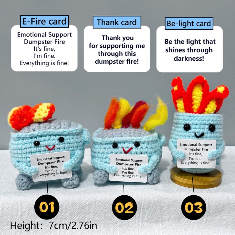 May include: Three crocheted dumpster fire figures, each with a unique flame design. The figures are light blue with smiling faces and hold small signs. The height is 2.76 inches.