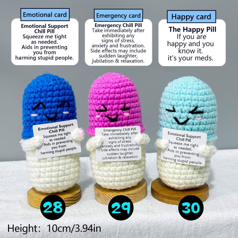 May include: Crocheted pill-shaped figurines in blue, pink, and light blue, each with a smiling face and a small card. The cards read "Emotional Support Chill Pill," "Emergency Chill Pill," and "Happy Pill." Height is 3.94 inches.