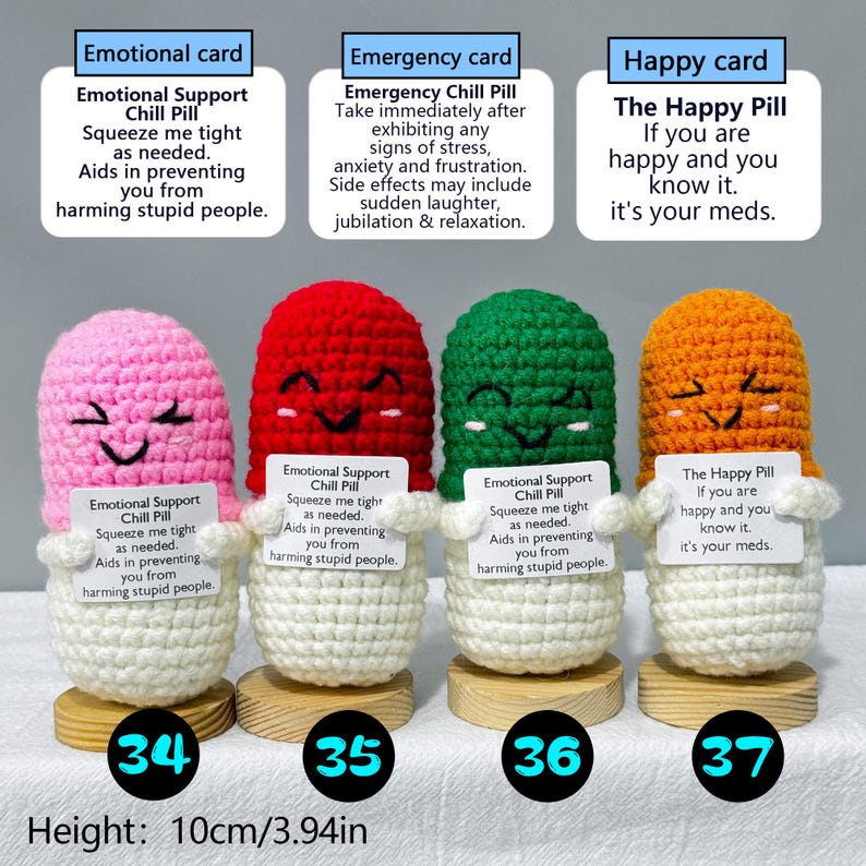 May include: Four crocheted pill-shaped figures in pink, red, green, and orange, each with a smiling face. Each figure holds a small card with text. The height is 3.94 inches. The figures are on wooden bases.