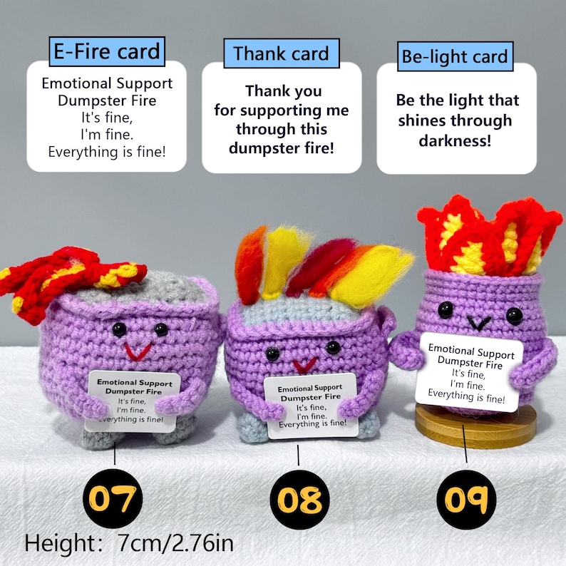 May include: Three handmade crochet figures with purple bodies, each with a different colorful flame-like top. Each figure holds a card with the text "Emotional Support Dumpster Fire." The height is 2.76 inches.