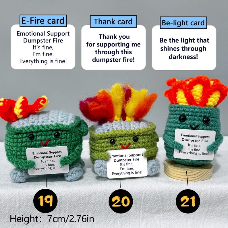 May include: Three crocheted dumpster fire figures with smiling faces and flames. Each figure holds a card with text. The height is 2.76 inches (7 cm). The text on the cards reads: "Emotional Support Dumpster Fire. It's fine, I'm fine. Everything is fine!"