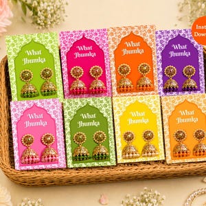 May include: Eight pairs of gold-toned jhumka earrings displayed on colourful rectangular cards with the text What Jhumka. Each card features a unique background colour including lime, pink, orange, purple, magenta, olive, yellow, and gold.