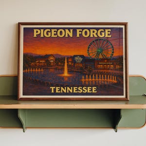 May include: A framed print of Pigeon Forge, Tennessee, featuring a Ferris wheel, buildings, and a water fountain. The print has a brown frame and is displayed on a green shelf. The text "PIGEON FORGE" and "TENNESSEE" are visible.
