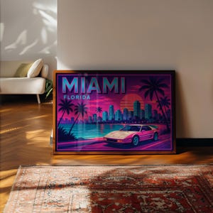 May include: Framed art print featuring a retro Miami, Florida design. The artwork showcases a pink sports car, palm trees, and a cityscape against a vibrant sunset. The word "MIAMI" is prominently displayed.