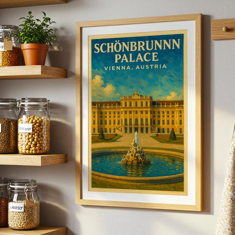 May include: Framed art print of Sch&ouml;nbrunn Palace in Vienna, Austria. The artwork features a yellow palace with a fountain in front, set against a blue sky. The print is in a light brown wooden frame and is displayed on a wall.