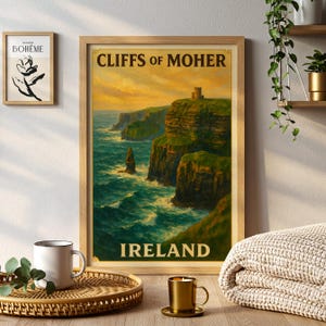 May include: A framed print of the Cliffs of Moher in Ireland, with the text "Cliffs of Moher" and "Ireland". The artwork depicts the green cliffs, the ocean, and a castle on top of the cliffs. The print is in a wooden frame.