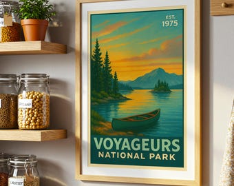 Peut inclure: Impression encadrée du parc national des Voyageurs. L'œuvre représente une scène de lac avec un canoë, des arbres et des montagnes sous un ciel de coucher de soleil. Le texte "EST. 1975" et "VOYAGEURS NATIONAL PARK" sont visibles.