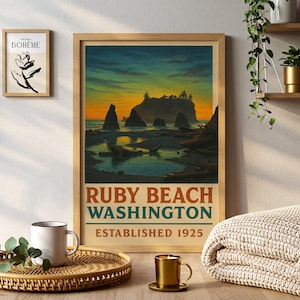 May include: A framed print of Ruby Beach, Washington, with a sunset over the ocean and rock formations. The print has text that reads "Ruby Beach Washington Established 1925". A smaller framed print and a coffee mug are also visible.