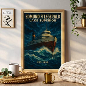 May include: A framed vintage print depicting the Edmund Fitzgerald on Lake Superior. The artwork features a ship navigating stormy waters, with text reading "EDMUND FITZGERALD LAKE SUPERIOR" and "EST. 1958." The colour scheme is dark blue and red.