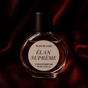 May include: A round perfume bottle with a black cap. The bottle has a white label with the words "ÉLAN DE LUXE" and "ÉLAN SUPRÊME" in black text. The label also reads "L'HUILE PARFUM 15 ml / 0.5 fl oz". The bottle is filled with a brown liquid.