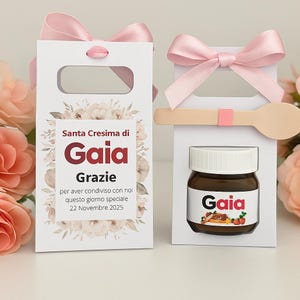 Può includere: Due scatole regalo in cartone bianco con fiocchi in raso rosa. Una scatola presenta un motivo floreale con il testo Santa Cresima di Gaia Grazie per aver condiviso con noi questo giorno speciale 22 Novembre 2025. L'altra contiene un vasetto etichettato Gaia.